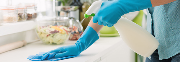 Die Küche wird mit Putzmittel und Lappen geputzt., um Magen-Darm-Beschwerden vorzubeugen