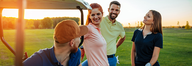4 Freunde unterhalten sich bei einer Runde Golf ganz ohne Stress