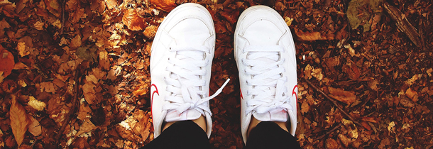 Weisse Turnschuhe sind während dem Sport im herbstlichen Wald