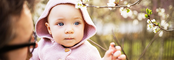 Baby mit Hellblauen Augen ist in der Natur trotz Pollenallergie und blickt in die Ferne