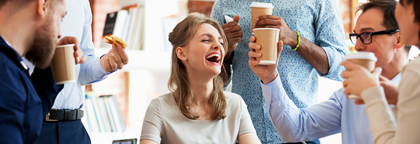 Eine Gruppe junger Arbeitskollegen trinken gemeinsam Kaffee und wirkt so der Müdigkeit am Arbeitsplatz entgegen