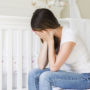 Eine junge Mutter ist traurig und müde während dem Baby Blues