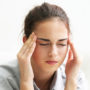 Eine junge Frau ist von Migräne geplagt