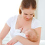 Eine junge Frau gibt ihrem Baby die Brust und stillt es mit Muttermilch