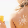 Eine mit Sonnencreme eingeriebene Rücken einer jungen Frau am Strand schützt sich vor der Sonne