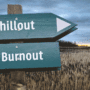 Ein Wegweiser befindet sich nahe eines Kornfelds, wobei in einer Richtung "Burnout"