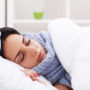 Eine Dame liegt mit Grippe im Bett